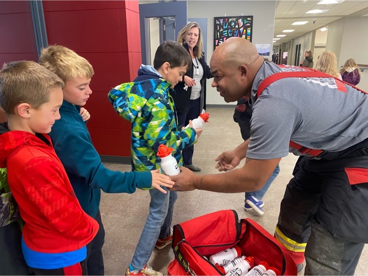 Jimmy handing out water bottles filled with goodies to the 3rd grade